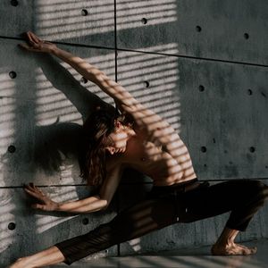 Shadow of a person performing a graceful stretching movement.
